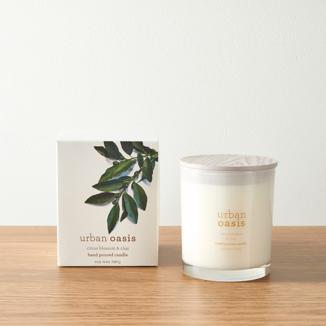 Urban Oasis No.2 soy candle beside its gift box on a timber bench